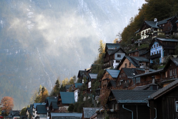 Die charakteristischen Häuser mit Holzfassade am Berghang über dem Ortskern in Hallstatt sind zu sehen.