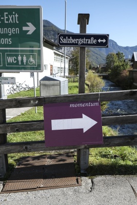 Straßenschild der Salzbergstraße unter dem ein Momentum Schild den Weg um SchülerInnenheim weist.